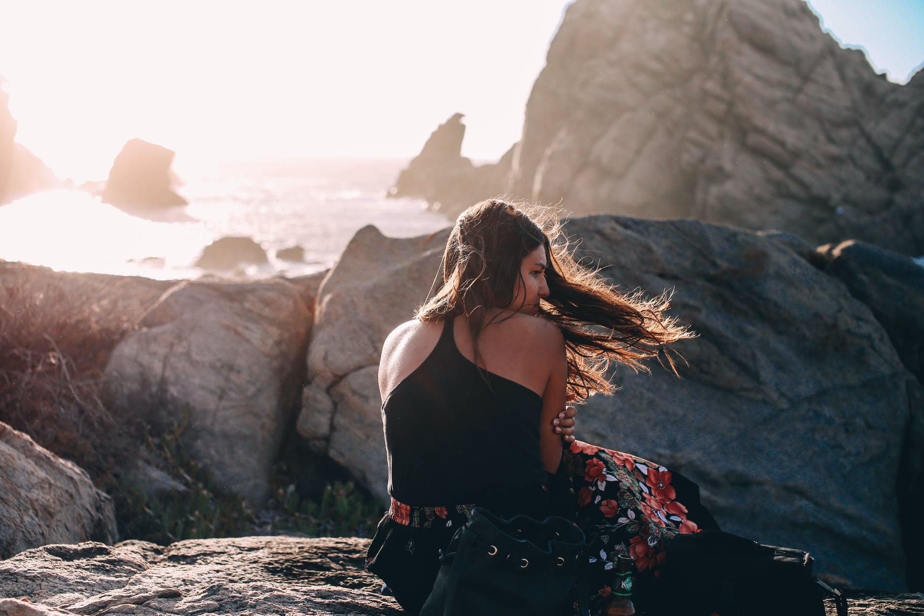 calm woman on rocky seashore on windy day